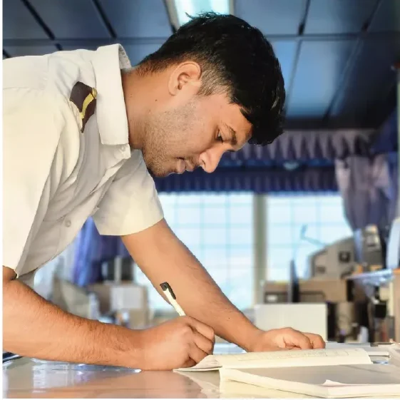 Aman Joshey, co-founder of NauTutor and Merchant Navy officer, preparing academic material onboard to guide IMUCET and DNS aspirants